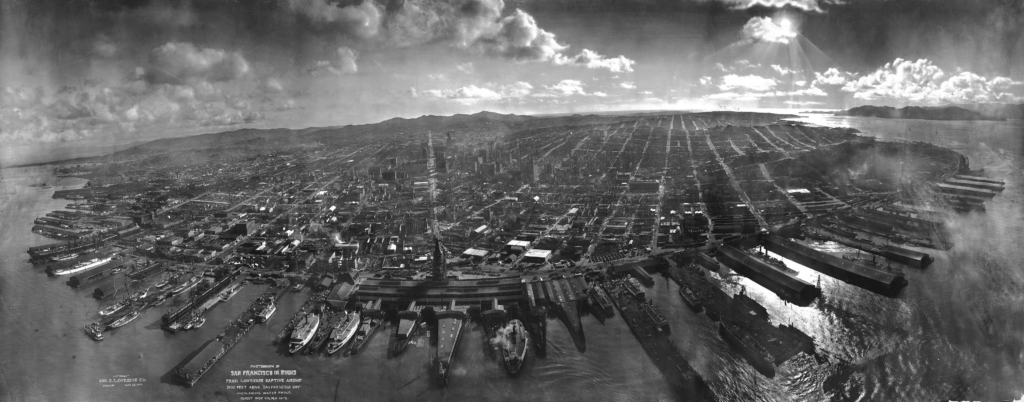 San Francisco in ruins, waterfront in foreground, with sunset over Golden Gate in background, looking from 2,000 feet (610 m) above San Francisco Bay, by George R. Lawrence using kite aerial photography. Copyright May 28, 1906. Market Street leads directly away from Ferry Building tower, center foreground, towards Twin Peaks, center-left background. Source: Wikipedia https://en.wikipedia.org/wiki/1906_San_Francisco_earthquake